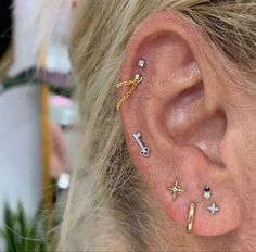 a woman with ear piercings on her ears and behind the ear is a small star