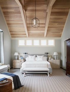 a bedroom with wood ceiling and white bedding