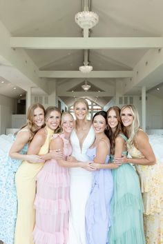 a group of women standing next to each other in front of a chandelier