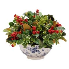 a blue and white vase filled with red berries and green leaves on top of a table