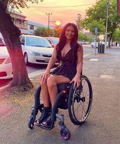 a woman sitting in a wheel chair on the street