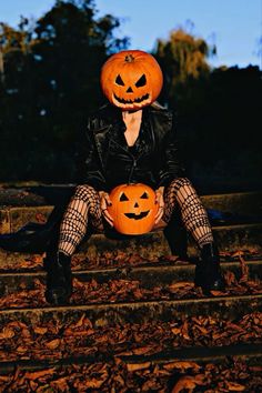 a woman sitting on steps with two pumpkins in front of her face and legs