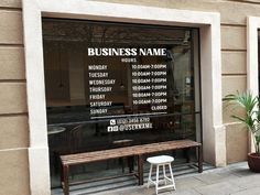 a bench in front of a business name sign on the side of a store window