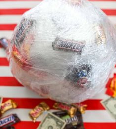 a bag filled with candy sitting on top of a red and white striped table cloth