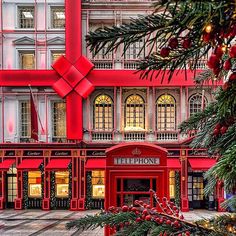 a large red building with christmas decorations on the front and side of it's windows