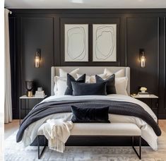 a bedroom with black and white bedding, two framed pictures on the wall above it