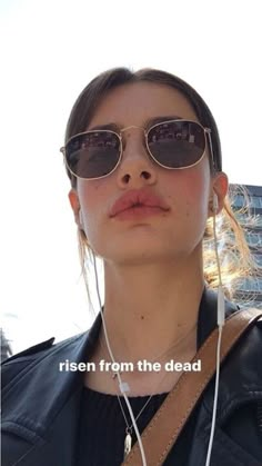 a woman wearing sunglasses and headphones with the words rise from the dead on it