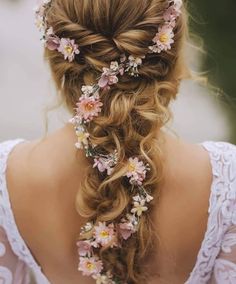 a woman with long hair and flowers in her hair is shown from the back view