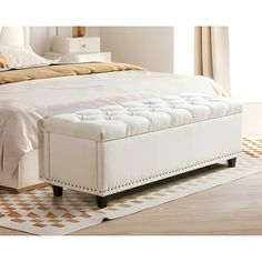 a large white bed sitting on top of a wooden floor