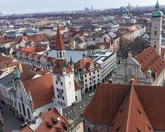 an aerial view of a city with red roofs and tall buildings in the foreground