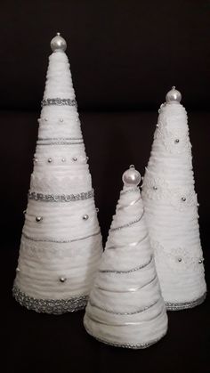 three white ceramic christmas trees on a black background