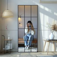 a woman taking a selfie with her cell phone while sitting in front of a mirror