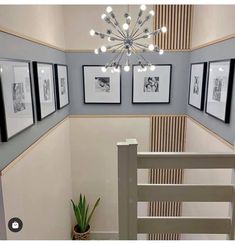 a staircase with pictures on the wall and a chandelier