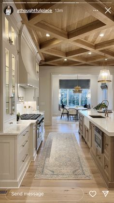 a large kitchen with wooden ceiling and white cabinets, along with an area rug on the floor