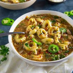 a white bowl filled with pasta and green peppers