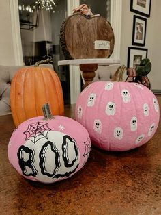 three painted pumpkins sitting on top of a table