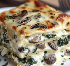 a stack of lasagna casserole with mushrooms and spinach on top