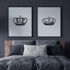 two black and white pictures hanging on the wall above a bed in a room with gray walls