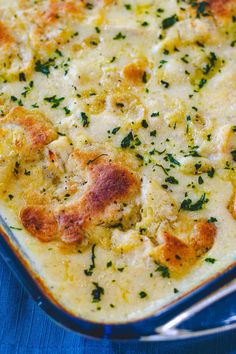 a casserole dish with cheese and herbs in it on a blue table cloth