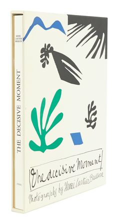 an open book with black and green designs on the cover, sitting on a white surface