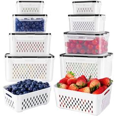 four plastic containers filled with different types of berries and strawberries in each container, all stacked on top of each other