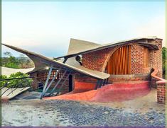 an artistic building with red brick and green roof