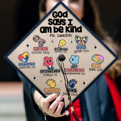 a woman holding up a graduation cap with stickers on it that says god sogs i am be kind