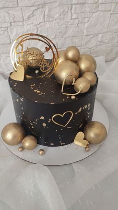 a black and gold cake with ornaments on top