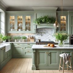 a kitchen with green cabinets and marble counter tops, along with potted plants on the island