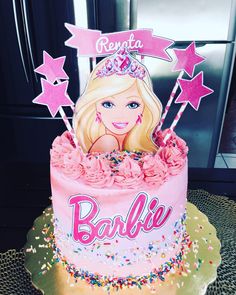 a barbie doll birthday cake with pink frosting and sprinkles on top