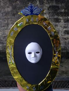 a person with a mask on their face is standing in front of a round mirror