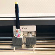 a close up of an electronic device on a table near a window sill with the word cricut printed on it