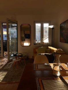 a living room filled with furniture and large windows