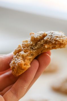 a hand holding a cookie in the palm of it's left hand with powdered sugar on top