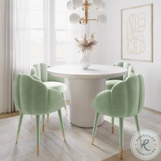 a white dining room table surrounded by green chairs