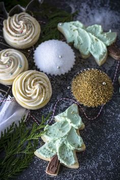 some cookies are decorated with icing and sprinkles on a black table