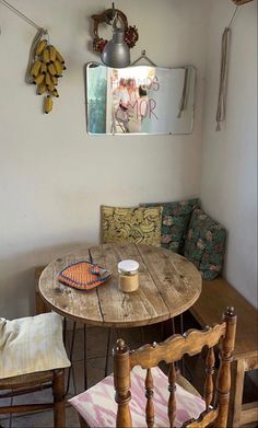 a wooden table with two chairs and a bench in the corner next to it,