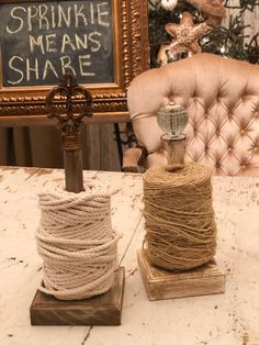 two spools of twine sitting on top of a table next to a cross