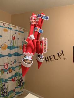 the elf is hanging upside down in the bathroom with toothbrushes and toothpaste