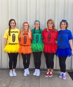 four girls in costumes standing next to each other with their hands on their hipss