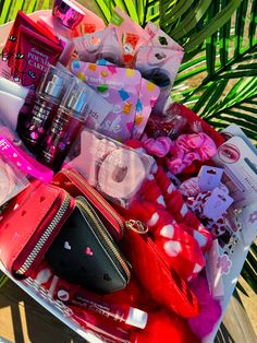 an assortment of cosmetics and other items in a plastic container next to a palm tree