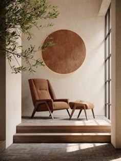 a chair and foot stool in front of a round wall hanging on the side of a building