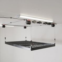 an overhead lighting fixture suspended from the ceiling in a room with white walls and flooring