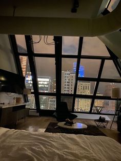 a bedroom with large windows overlooking the city