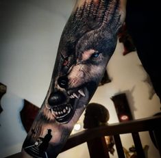 a man's arm with a wolf tattoo on it