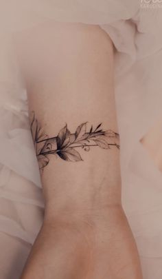 a woman's wrist tattoo with leaves on it