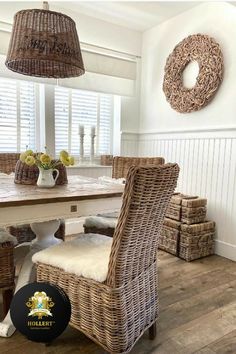 a wicker dining table and chairs in a room with white walls, wood floors and windows