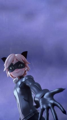 a catwoman doll is posed in front of a purple background