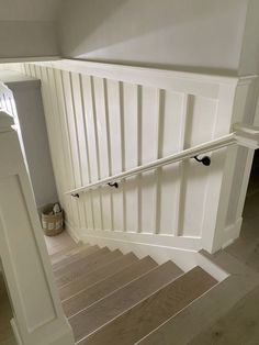 the stairs are made of wood and have white painted railings on them, along with an open banister door