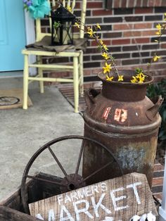 a sign that says farmers market next to an old wagon with flowers in it on the front porch